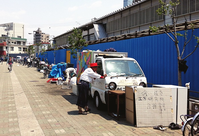 Vecino de Nishinari afeitándose en su coche-casa con la ayuda del retrovisor